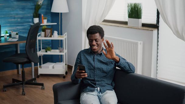Afrykański amerykański facet pozdrawiając kolegów lub rodzinę podczas rozmowy online wideokonferencji - Zdjęcie, obraz