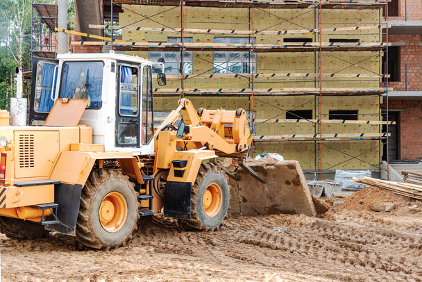 A forklift at a construction site is lifting a reinforced concrete slab. Construction machine. Industry - Foto, Bild