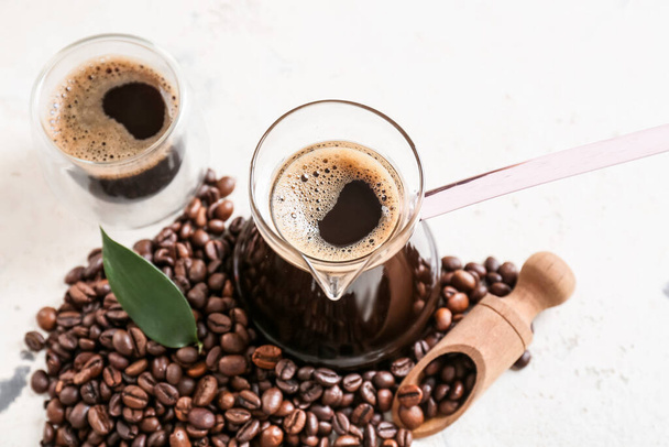 Pot en kopje met heerlijke Turkse koffie op lichte achtergrond - Foto, afbeelding