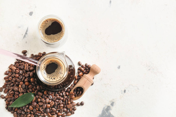 Pentola e tazza con delizioso caffè turco su sfondo chiaro - Foto, immagini