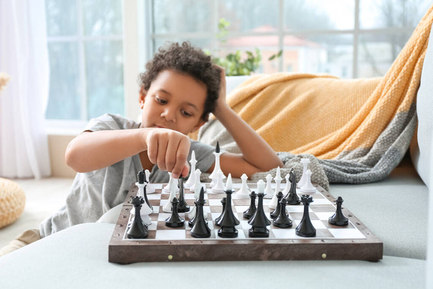 Roztomilý Afroameričan chlapec hraje doma šachy - Fotografie, Obrázek