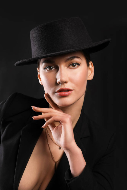 Beautiful young woman in stylish hat on dark background - Foto, Imagem