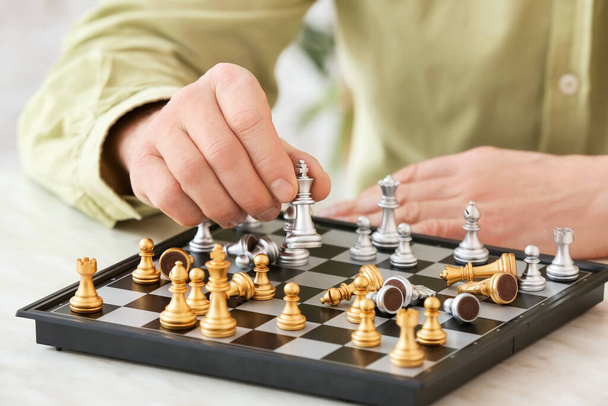 Άνθρωπος που παίζει σκάκι σε ξύλινο τραπέζι, κοντινό πλάνο - Φωτογραφία, εικόνα