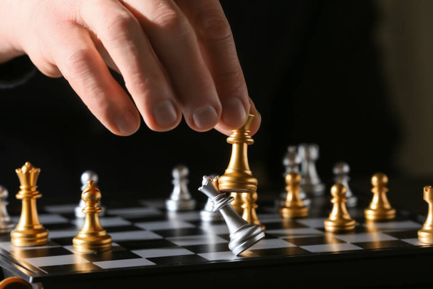 Mann spielt Schach auf dunklem Hintergrund, Nahaufnahme - Foto, Bild