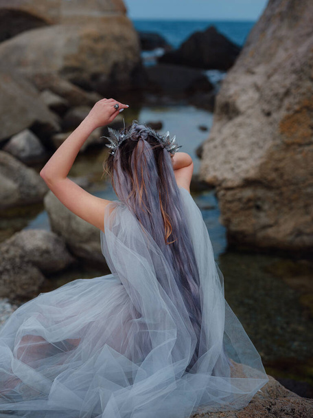 a beautiful woman like a fairy or nymph walking in the park. fairy tale image art photo. nymph of sea breathing ocean fresh air - Photo, Image