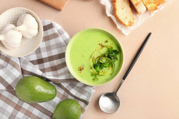 Bowl with green gazpacho and ingredients on color background - Fotó, kép