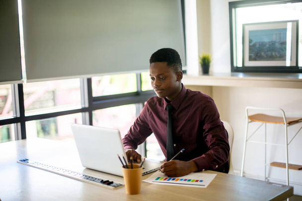 portret van hedendaagse Afro-Amerikaanse man met laptop aan tafel in coffeeshop, kopieerruimte - Foto, afbeelding