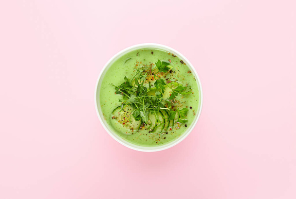 Bowl with green gazpacho on color background - Фото, изображение