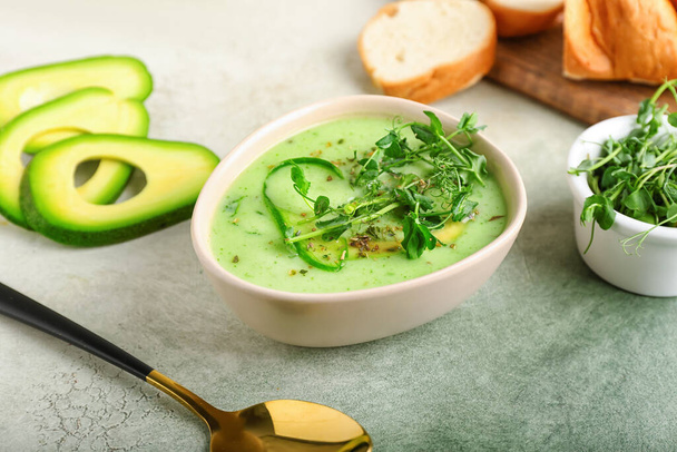 Bowl with green gazpacho and ingredients on color background - Foto, imagen