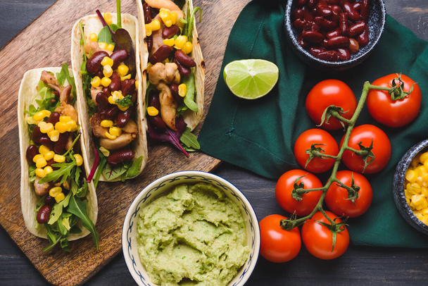 Bowl maukasta guacamole ja tacoja tumma puinen tausta - Valokuva, kuva