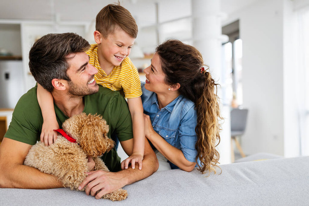 Portrait of happy family with a dog having fun together at home. Concept of happy family, love for animals, childhood - Zdjęcie, obraz