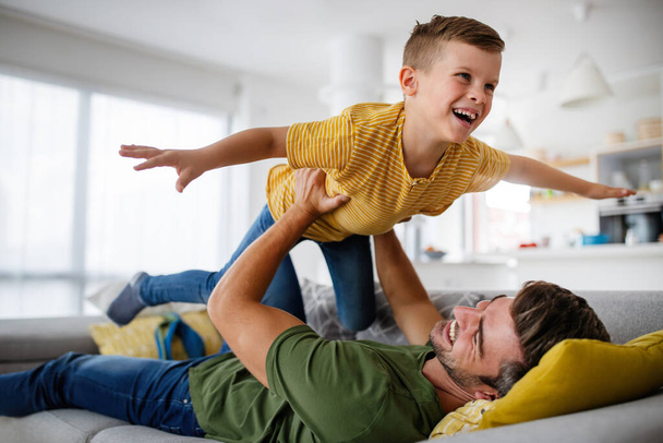 Happy family concept. Handsome father playing with son at home. - Fotó, kép