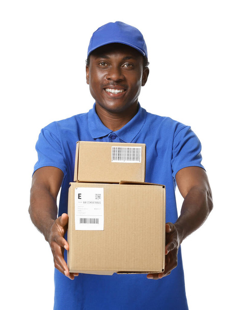 African-American delivery man with parcels on white background - Fotoğraf, Görsel