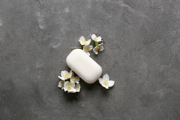 Soap bar and flowers on dark background - 写真・画像