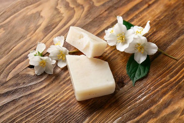 Σαπούνι μπαρ και λουλούδια σε ξύλινο φόντο - Φωτογραφία, εικόνα