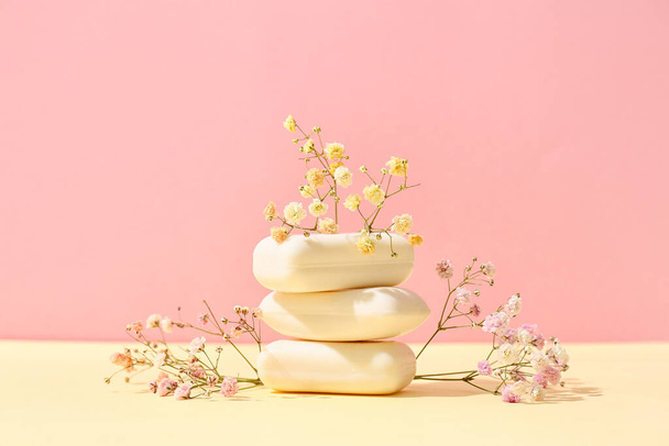 Stack of soap bars and flowers on color background - Photo, Image