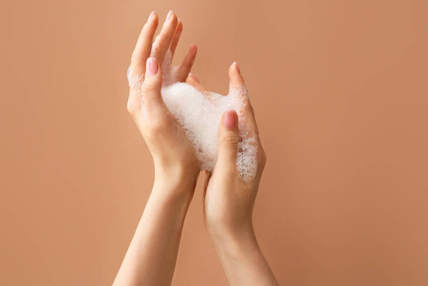 Donna lavarsi le mani con sapone su sfondo colore - Foto, immagini