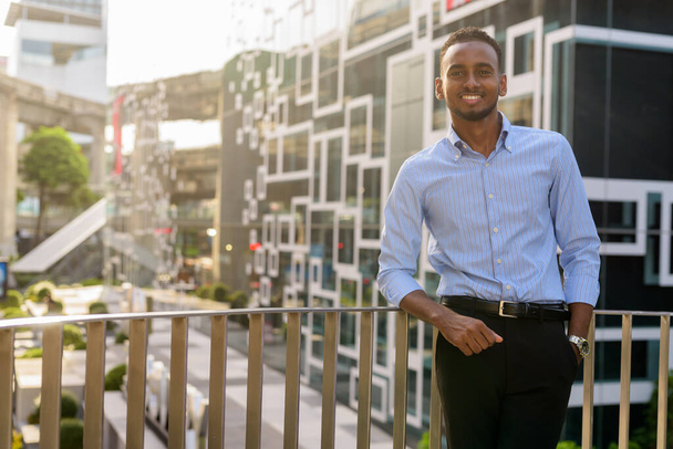 Porträt eines glücklichen schwarzafrikanischen Geschäftsmannes im Sommer draußen in der Stadt - Foto, Bild