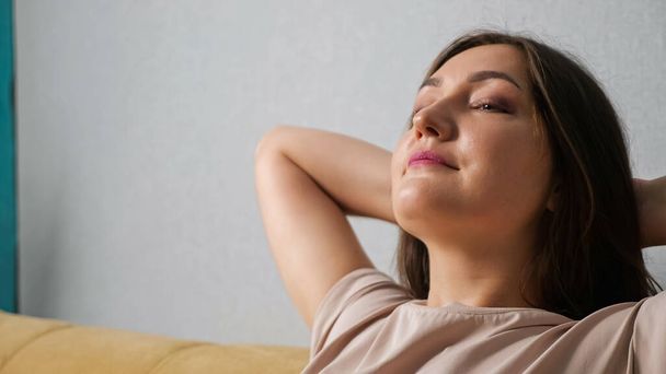 mujer disfrutando del viento del ventilador mientras está sentada en el sofá, primer plano - Foto, Imagen