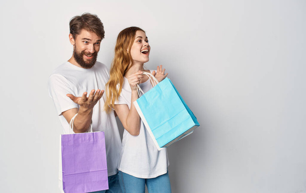 cheerful young couple with packages in their hands shopping entertainment friendship - Foto, Imagem