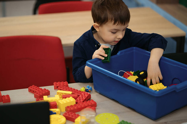 Μικρό παιδί αγόρι που διασκεδάζει με την οικοδόμηση και τη δημιουργία ρομπότ. - Φωτογραφία, εικόνα