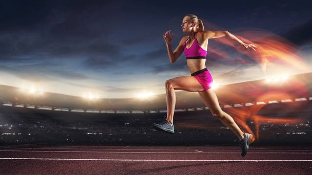 One professional female runner, jogger training at stadium in evening. Caucasian fit athlete practicing, Concept of sport, healthy lifestyle. - Photo, image