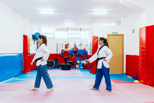 Deux jeunes femmes pratiquent le taekwondo dans un centre de formation - Photo, image