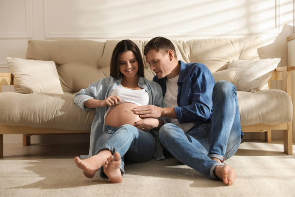 Young pregnant woman with her husband at home - Foto, imagen