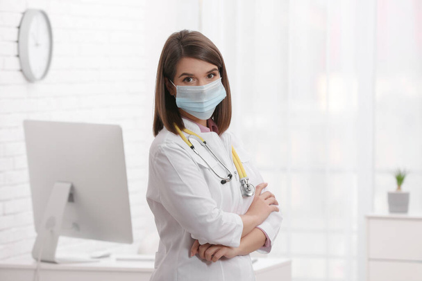 Pediatrician with protective mask and stethoscope in clinic - Zdjęcie, obraz