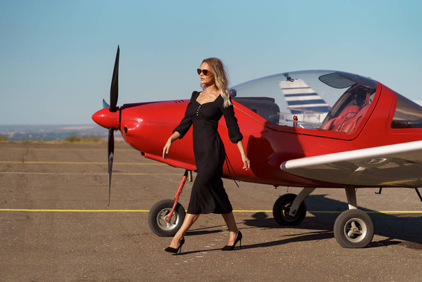 Glamorous woman posing on plane background - Valokuva, kuva
