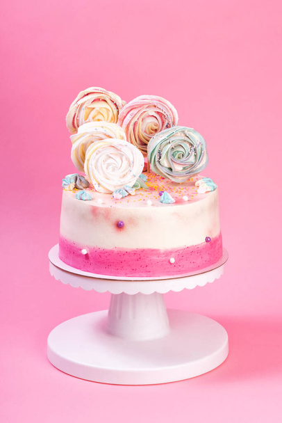 Syntymäpäivä vaaleanpunainen ja valkoinen kakku koristeltu värikäs marenki - Valokuva, kuva
