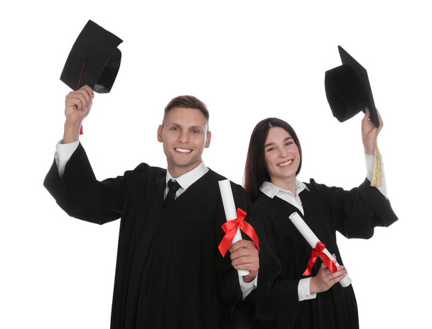 Happy students in academic dresses with diplomas on white background - Foto, Imagem