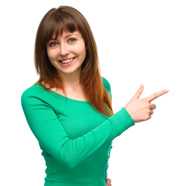 Portrait of a young woman pointing to the right - Foto, Imagem