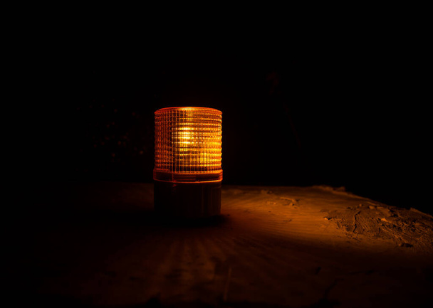 Vészvilágítás a gyárban, figyelmeztető fény, narancssárga sziréna a betonfalon. Forgó sziréna. - Fotó, kép
