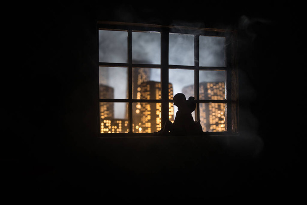 Hermosa vista de una ciudad en miniatura por la noche desde la ventana de la casa de muñecas. Pareja romántica en la ventana. Decoración de mesa de arte con casa de muñecas realista hecha a mano. Enfoque selectivo. - Foto, imagen
