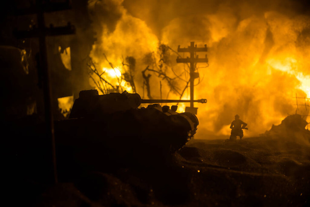 War Concept. Military silhouettes fighting scene on war fog sky background, World War Soldiers Silhouette Below Cloudy Skyline At night. Armored vehicle fight scene. Selective focus - Zdjęcie, obraz
