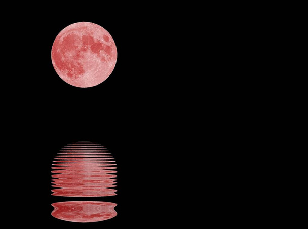 Heijastus merivesi uskomattoman iso punainen kuu ja keskiyön musta tähdetön taivas taustalla - Valokuva, kuva