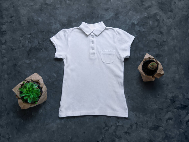 Άσπρο λευκό λευκό μπλουζάκι πόλο, μακιγιαρισμένο σε σκούρο φόντο. Λευκό βαμβακερό απλό πουκάμισο γιακά τσέπη πρότυπο για δημιουργικό σχεδιασμό. Casual ρούχα φωτογραφία για ιστοσελίδες, μέσα κοινωνικής δικτύωσης. Παιδικά ρούχα μόδας σχολείο. - Φωτογραφία, εικόνα