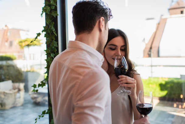 young woman drinking red wine near boyfriend  - Fotografie, Obrázek