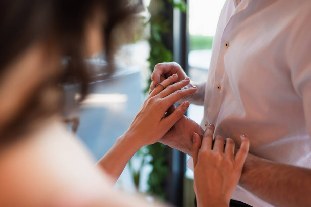 abgeschnittene Ansicht eines Mannes, der Verlobungsring am Finger einer Frau trägt - Foto, Bild