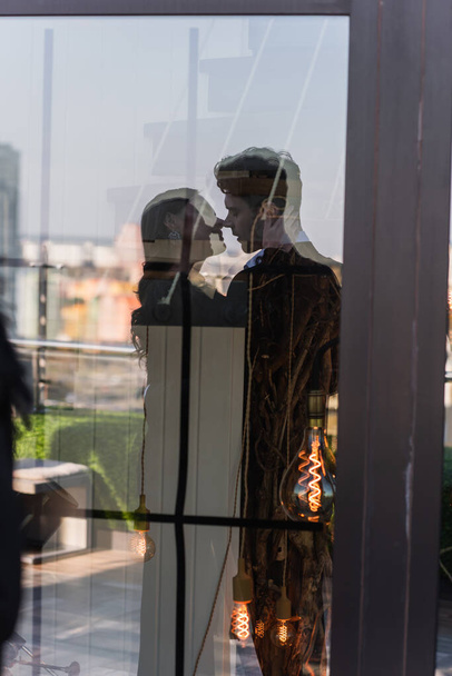 silhouette of loving couple in glass of window  - 写真・画像
