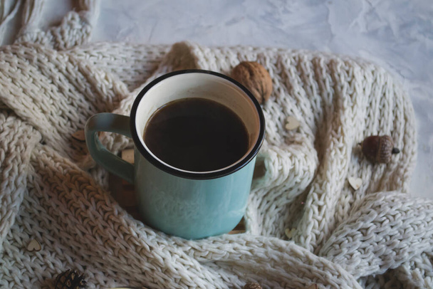 A cup of coffee and woolen scarf with decorations on a table. Coziness. - Fotoğraf, Görsel
