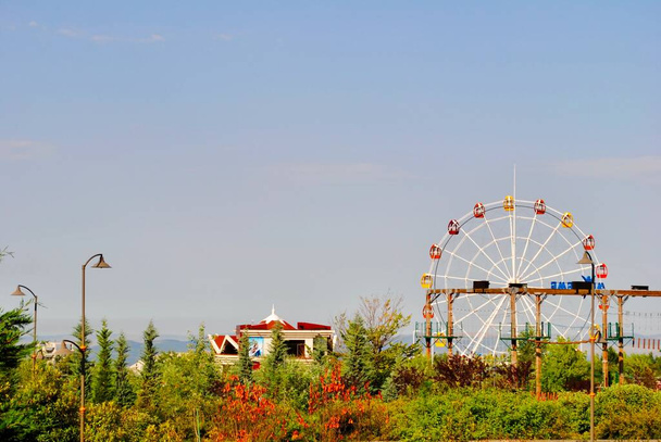 Die Touristenattraktion Riesenrad mit Blick auf die Kaukasusberge vor blauem Himmel. Gabala, Gebele, Aserbaidschan. - Foto, Bild