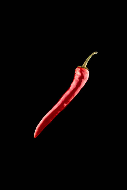 Cayenne chilli. Red hot chili paprika or spicy chile cayenne pepper isolated on black background. Fresh spice vegetable concept - Photo, Image