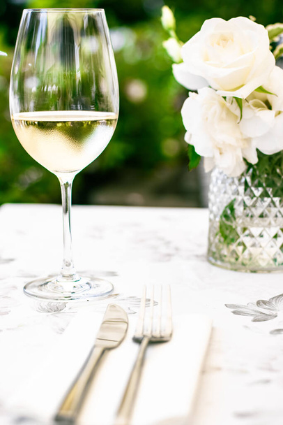 Witte wijn in luxe restaurant op zomerterras in de tuin, wijnproeverij in de wijnmakerij in de wijngaard, gastronomische tour en vakantie reizen - Foto, afbeelding
