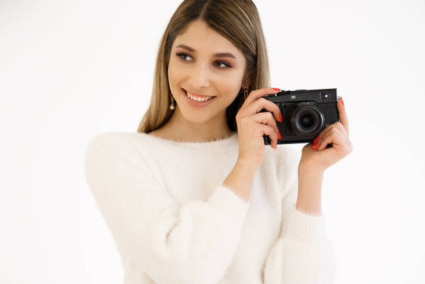 Femme souriante tenant la caméra sur fond blanc - Photo, image
