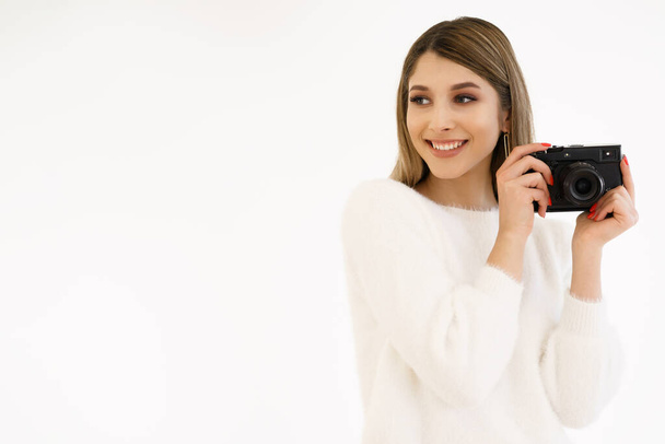 glimlachende vrouw houden camera op witte achtergrond - Foto, afbeelding