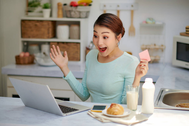Młoda azjatycka kobieta przy użyciu laptopa zakupy online z karty kredytowej kupić do Internetu i niespodzianka - Zdjęcie, obraz