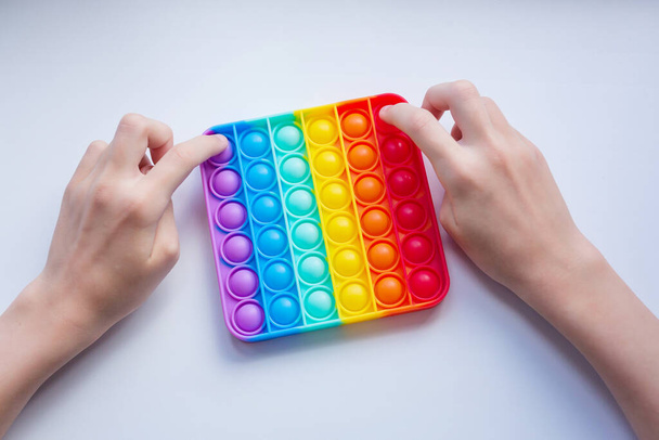 Antistress-Pop-it-Spielzeug. Regenbogen sensorische Fidget isoliert auf weißem Hintergrund. Neues trendiges Silikonspielzeug. - Foto, Bild