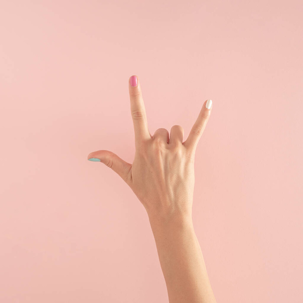 women hands with colorful nails on the pastel pink background. copy space.  summer modern tropical abstract art with female hand. minimal background idea with copy space - Foto, Imagem